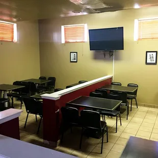 a restaurant with tables, chairs, and a flat screen tv