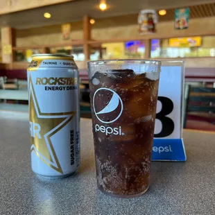 a glass of soda and a can of pepsi