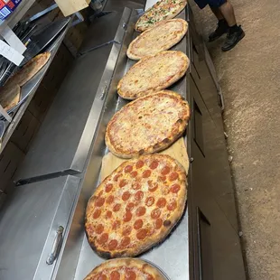 a row of pepperoni pizzas