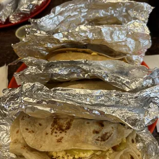 two burritos wrapped in aluminum foil