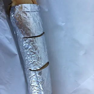 a sandwich wrapped in aluminum foil