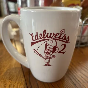 a white coffee cup with red lettering