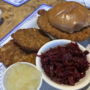 Pork Schnitzel Sandwich with potato pancakes and red cabbage.