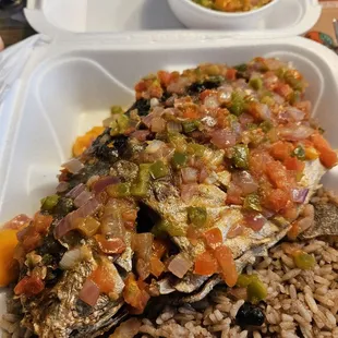 Fried pompano covered w hot sauce of Scotch Bonnets, rice and beans side.