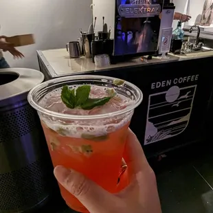 a hand holding a cup of iced tea