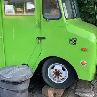 a green food truck parked on the side of the road