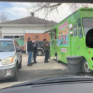 a group of people standing in front of a food truck