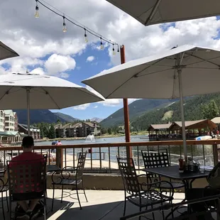 people sitting at tables with umbrellas