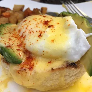 Eggs Benedict with tomato and avocado.  Fresh avocado slices. Perfectly poached eggs.  Not a lot of flavor but good.