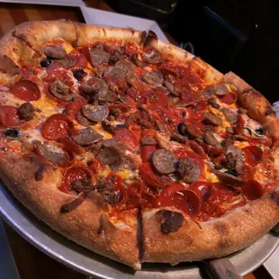 a pizza with pepperoni, sausage, and mushrooms