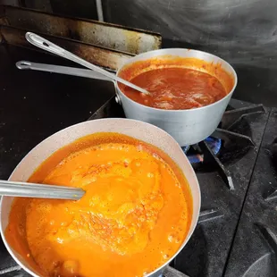 two pots of soup on a stove