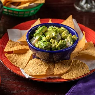 a bowl of guacamole and tortillas