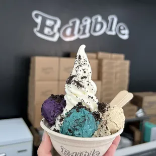 a hand holding a bowl of ice cream