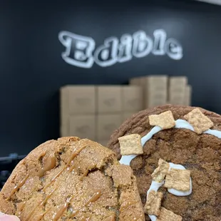 a hand holding a cookie and a bag of cookies