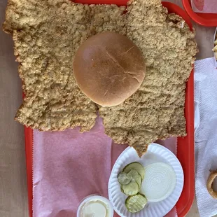 a fried chicken sandwich with a side of pickles