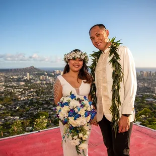 Newlyweds Jon and Laiza posing as a married couple in front of Diamond Head and Honolulu skyline.