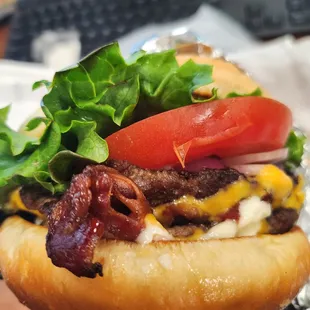 a hand holding a hamburger