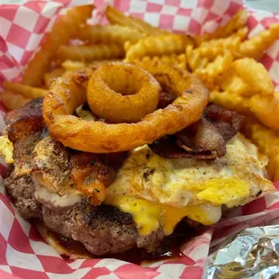 1/4 pound hand made patty with a slice of bacon, cheese, scrambled egg and onion rings on a bun!!