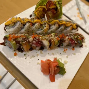 a plate of sushi with a side of sauce