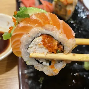 a close up of a sushi roll with chopsticks