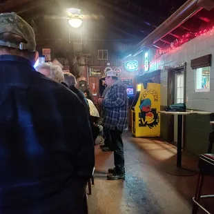 a man standing in front of a pinball machine