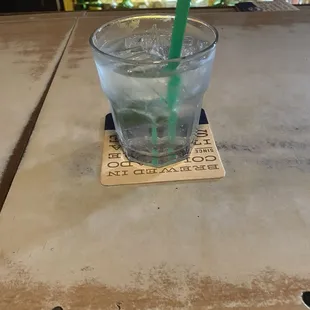 a glass of water with a green straw