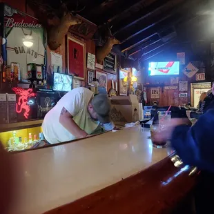 a man leaning over a bar