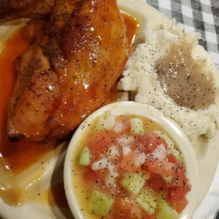 BBQ chicken breast, creamed potatoes with gravy,  and tomato cucumber salad