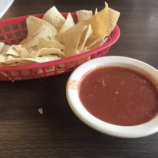 a basket of chips and a bowl of salsa