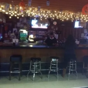 a bar with stools and lights