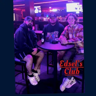three men sitting at a table
