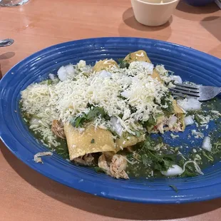 Chicken enchiladas salsa verde topped with cilantro and raw onions