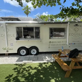 a food truck parked next to a picnic table