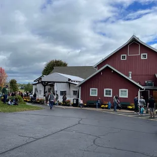 a red barn with a crowd of people standing in front of it