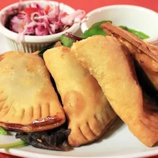  plate of empanadas with a side of coleslaw