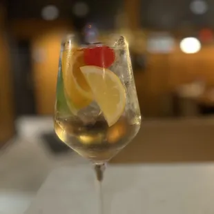 a glass of wine with a slice of lemon