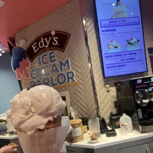 a person holding a cone of ice cream