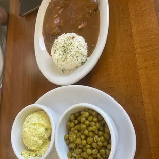 Smothered Chicken with potato salad and peas.