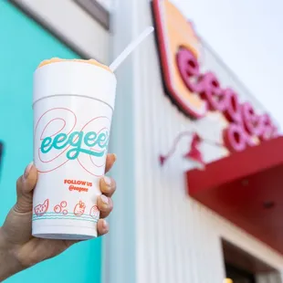 a hand holding a cup of ice cream