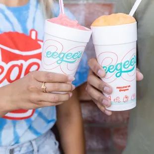 two people holding two cups of ice cream