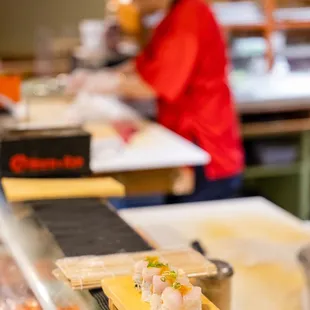 a woman preparing sushi rolls