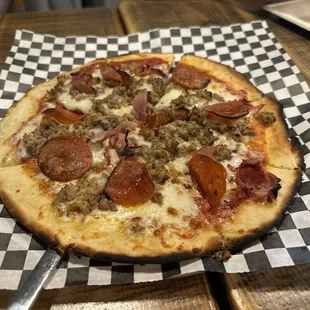 a pepperoni pizza on a checkered paper