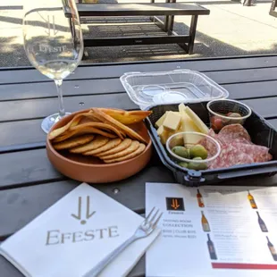 a tray of food and a glass of wine