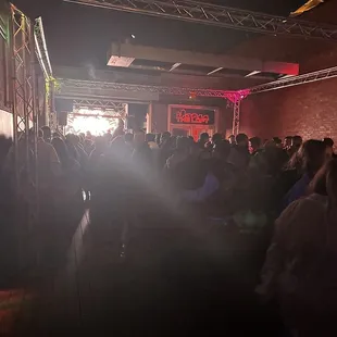 a crowd of people standing in front of a stage