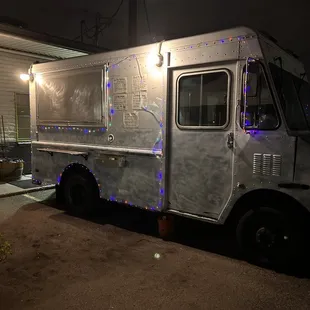 a food truck with christmas lights on it