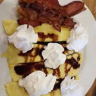 Crepes with thick bacon and topped with chocolate and whipped creme.