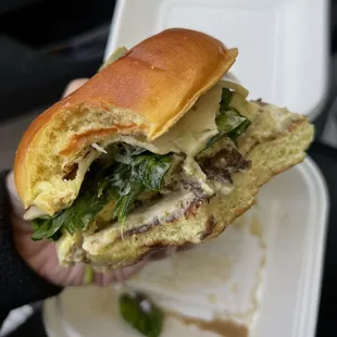 a hand holding a sandwich