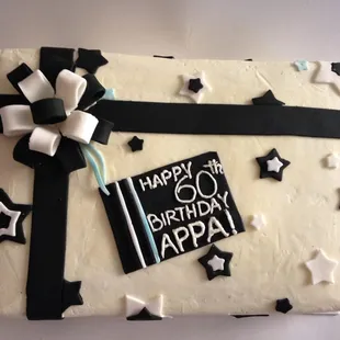 a birthday cake with black and white decorations