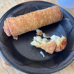 a half eaten egg roll on a plate