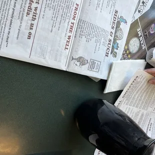 a person sitting at a table reading a newspaper